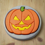 The Bumbu Toys Halloween Pumpkin Puzzle - Grey, laid on a wooden table