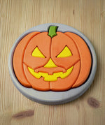 The Bumbu Toys Halloween Pumpkin Puzzle - Grey, laid on a wooden table