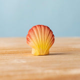 Bumbu handmade and hand painted orange and red wooden seashell figure with shell details available at Babipur. 