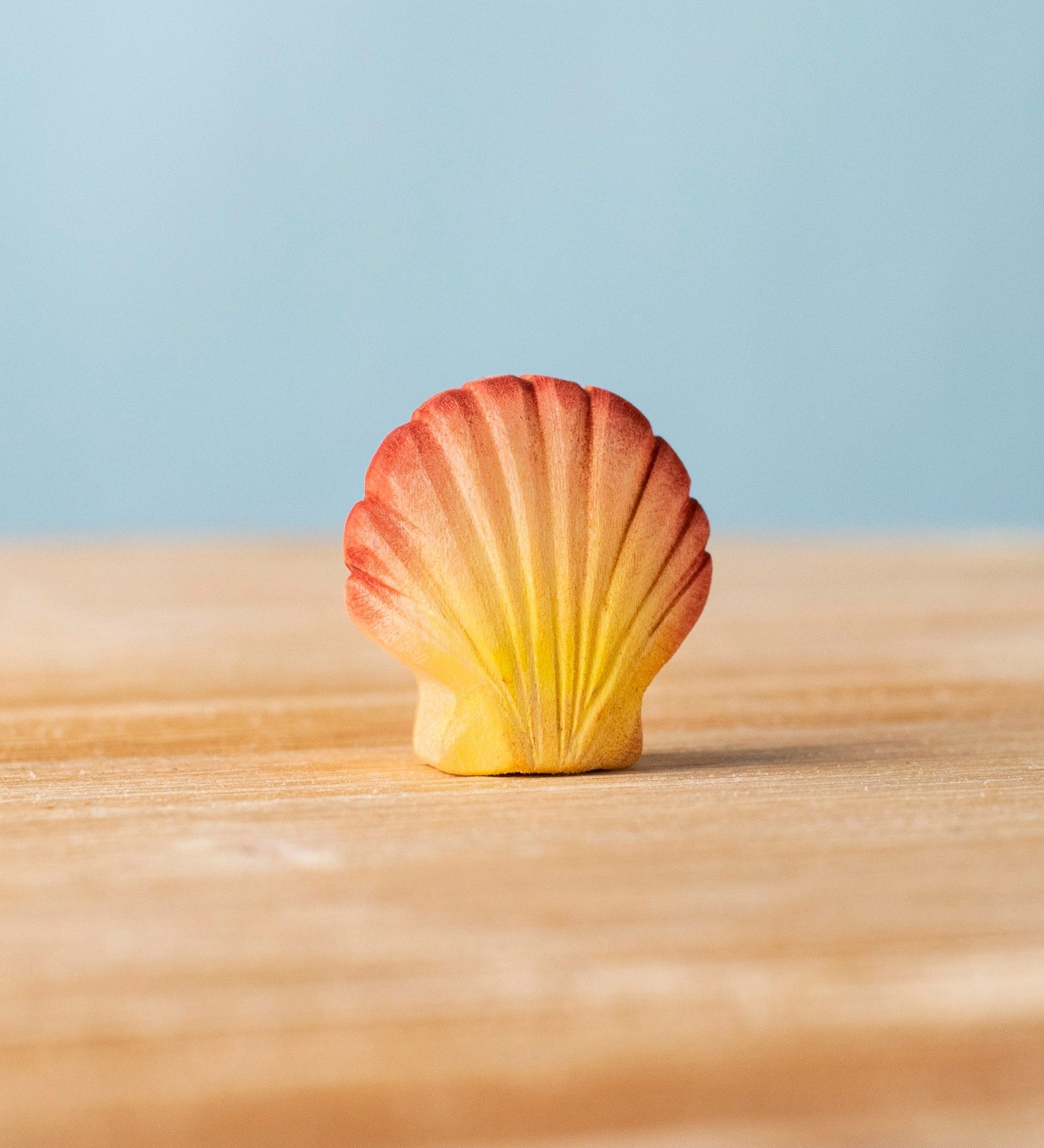 Bumbu handmade and hand painted orange and red wooden seashell figure with shell details available at Babipur. 
