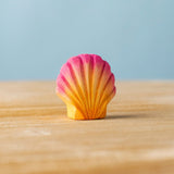 Bumbu handmade and hand painted orange and pink wooden seashell figure with shell details available at Babipur. 