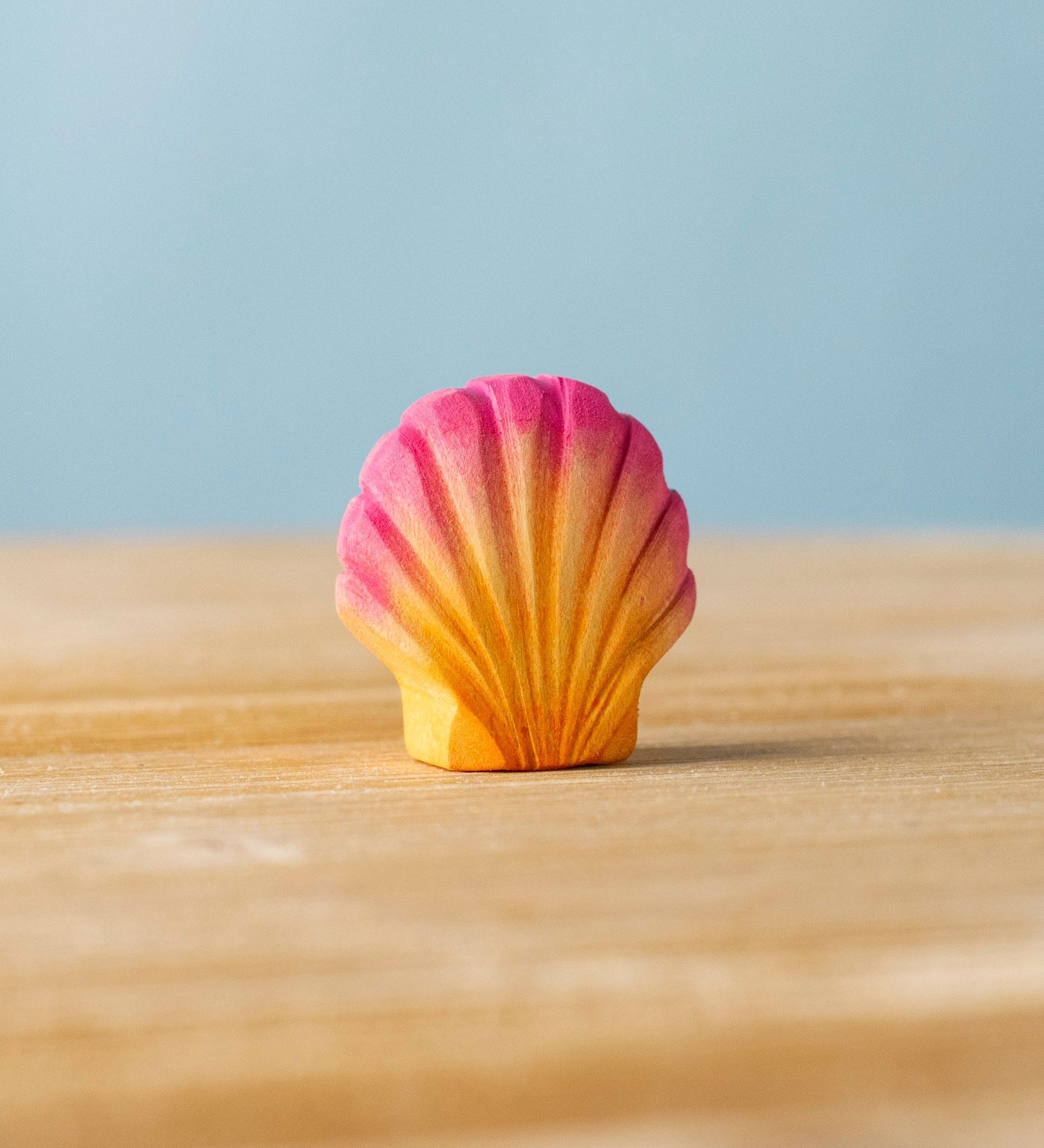 Bumbu handmade and hand painted orange and pink wooden seashell figure with shell details available at Babipur. 