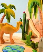 The Bumbu Wooden Saguaro Cactus Figure with red flowers in a desert oasis play scene