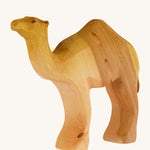 A Bumbu wooden camel figure on a plain background.