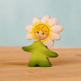 Bumbu handcrafted wooden daisy flower child figure with hand painted facial features standing on a wooden surface