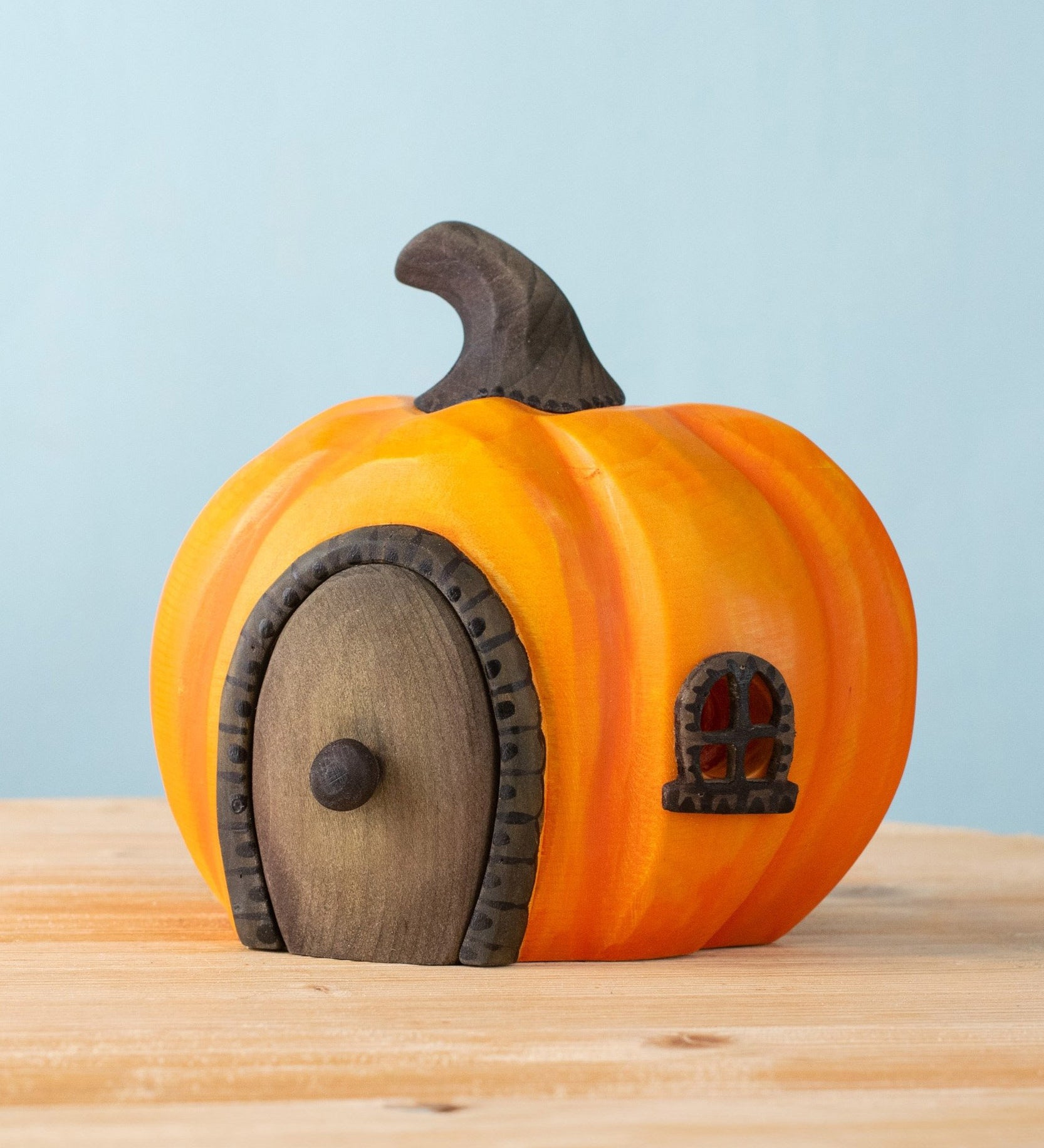 Bumbu handmade and hand painted wooden orange halloween pumpkin house available at Babipur. Features a black window window matching removable door