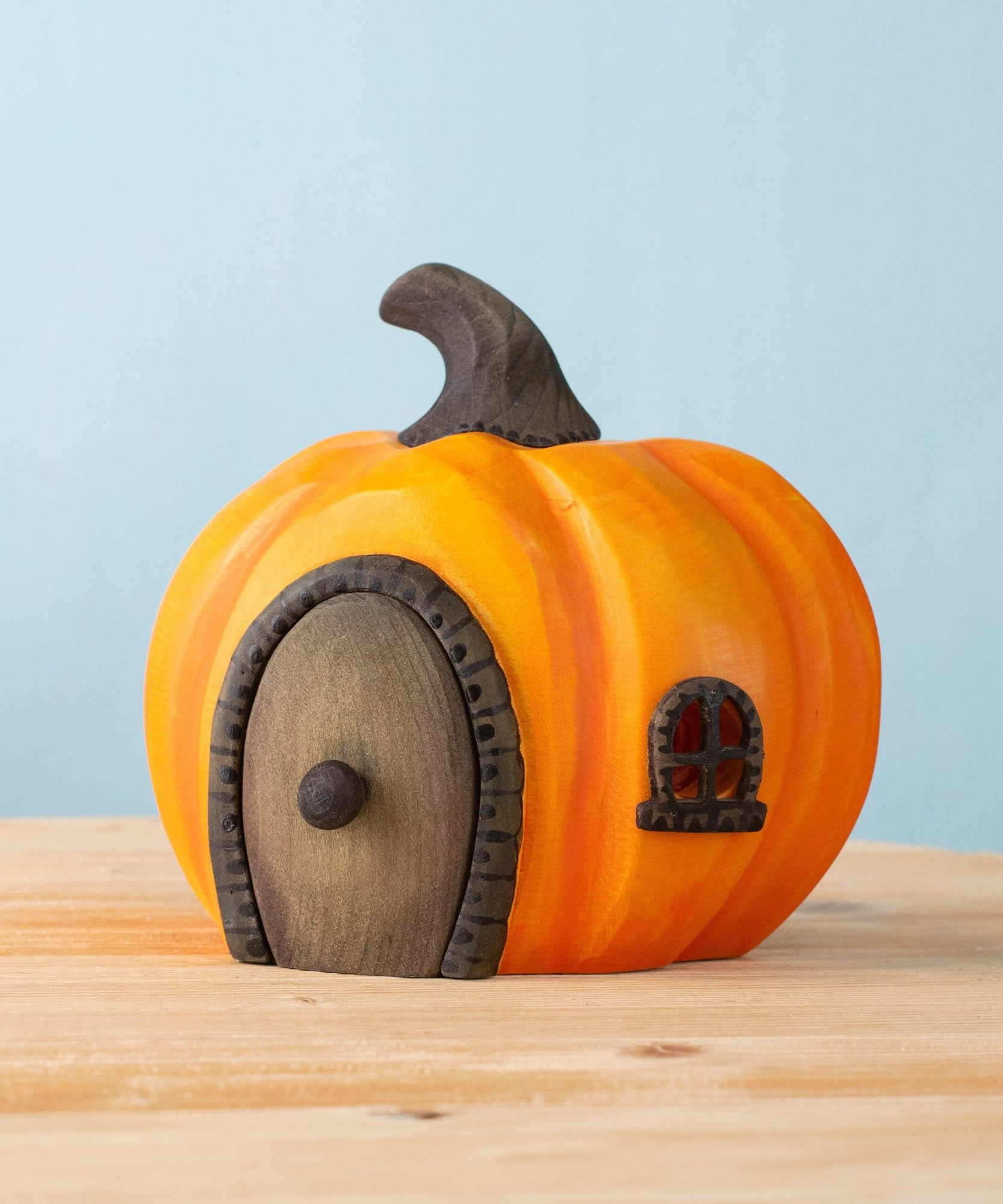 Bumbu handmade and hand painted wooden orange halloween pumpkin house available at Babipur. Features a black window window matching removable door
