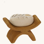 Bumbu wooden baby Jesus figure in a crib on a plain background.