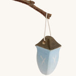 A small Bumbu wooden lantern toy on a cream background.
