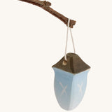 A small Bumbu wooden lantern toy on a cream background.