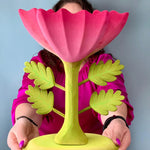 A person holding up the Bumbu Wooden Large Pink Flower in front of them.