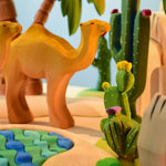  Bumbu wooden camel with palm trees and other Bumbu wooden cactus toys in the background. 