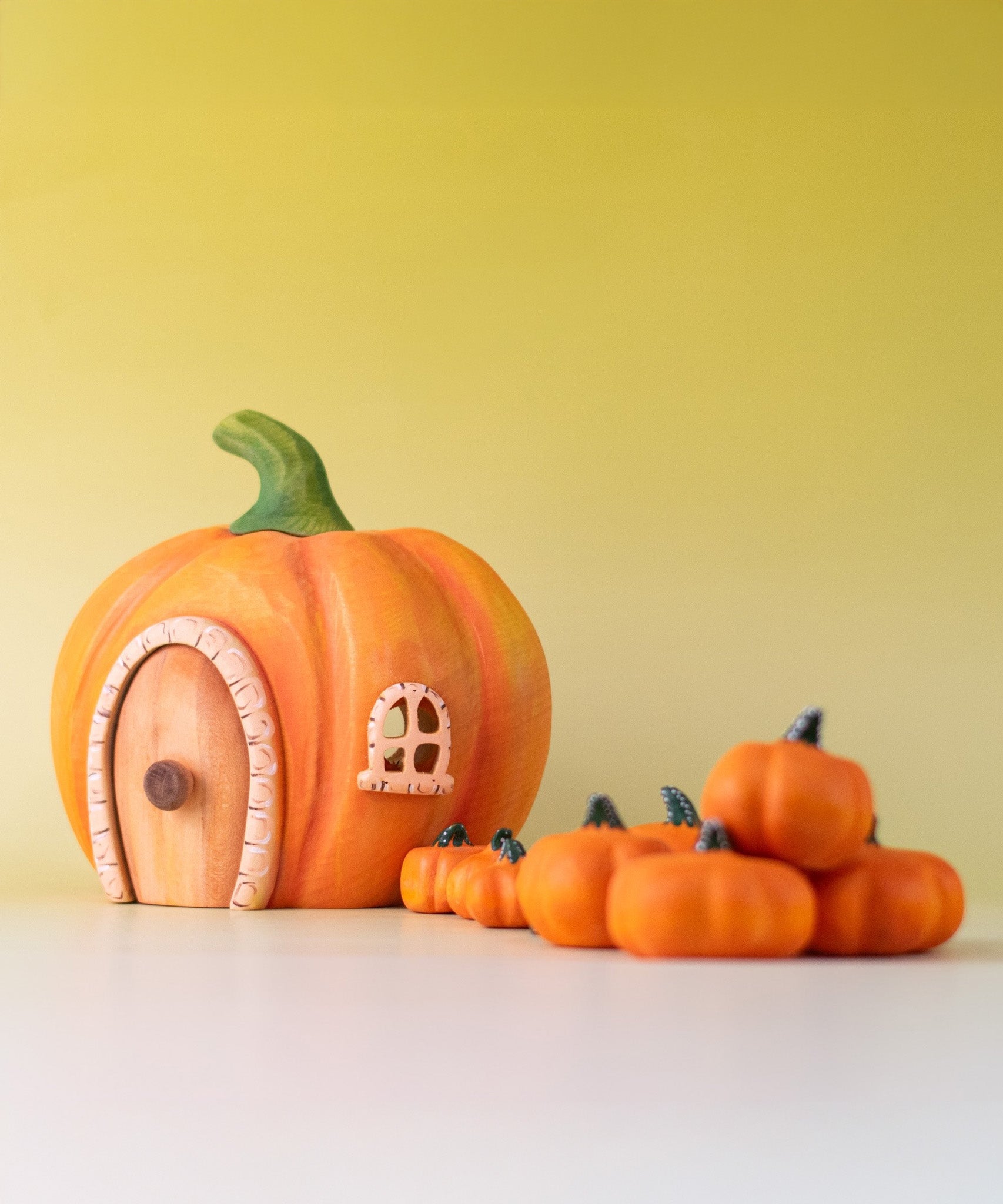 Bumbu handmade and hand painted wooden orange pumpkin house with small Bumbu pumpkin figures available at Babipur.