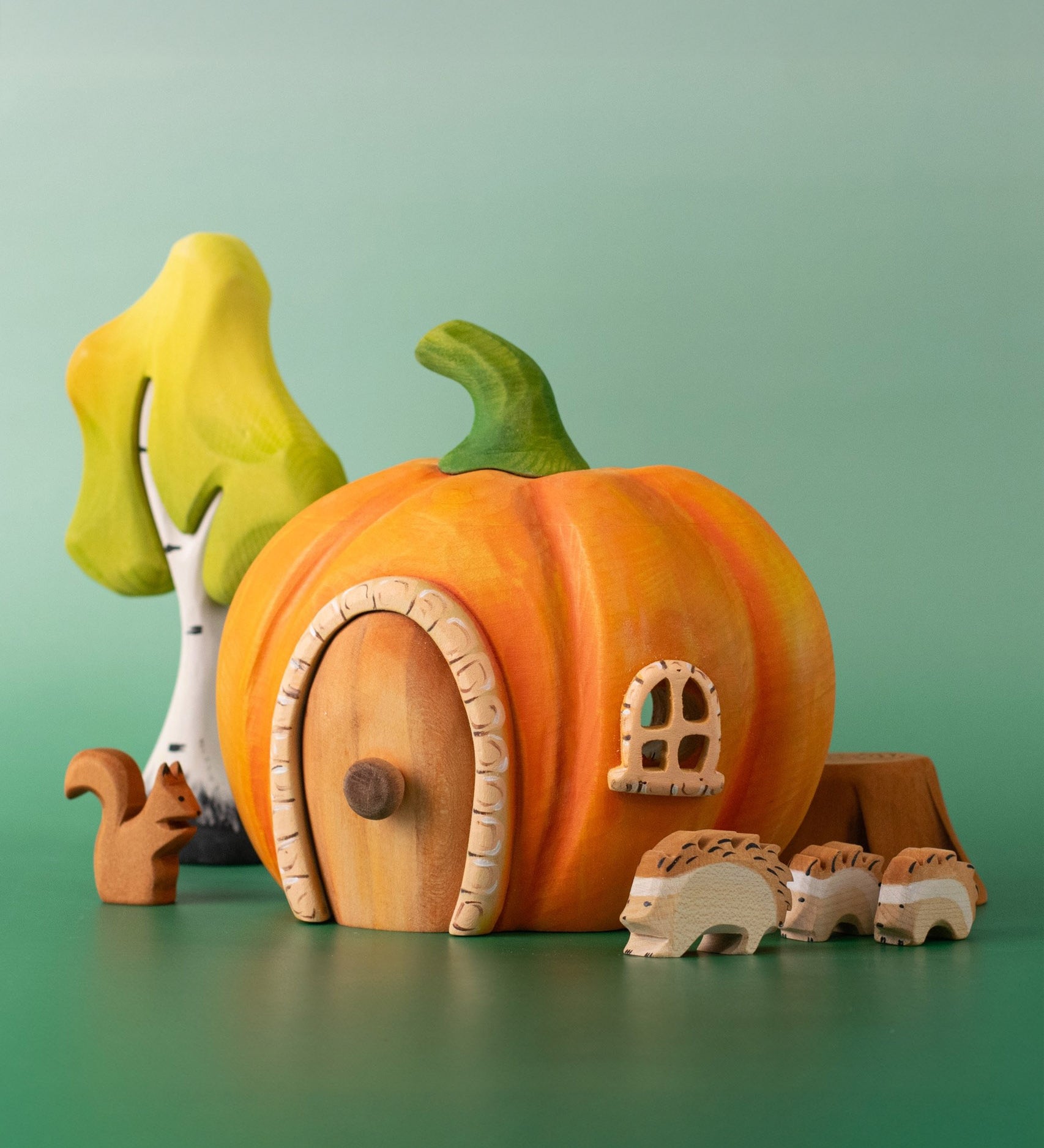 Bumbu handmade and hand painted wooden orange pumpkin house with other Bumbu woodland inspired figures including hedgehogs, a squirrel and a birch tree set available at Babipur.