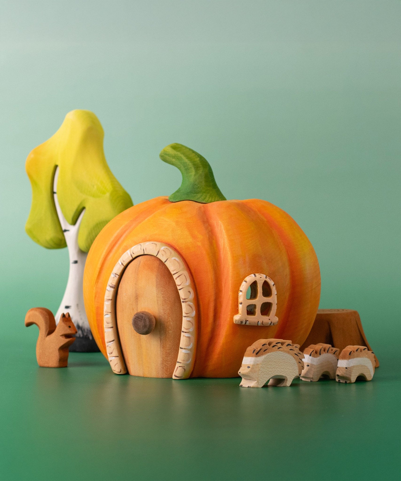 Bumbu handmade and hand painted wooden orange pumpkin house with other Bumbu woodland inspired figures including hedgehogs, a squirrel and a birch tree set available at Babipur.