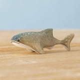 Bumbu handmade and hand painted wooden grey baby whale shark figure available at Babipur and resting on a wooden surface