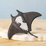 A close up of the  Bumbu handmade and hand painted wooden black manta ray figure showing the underside detail