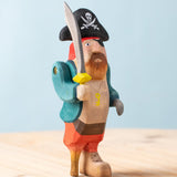Bumbu handmade and hand painted pirate wooden figure available at Babipur. Wearing a blue coat, red trousers and a black hat. Features a sword and a wooden leg
