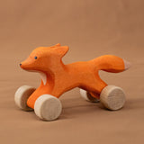 Bumbu handmade and hand painted rolling fox standing on a soft brown cloth
