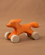 Bumbu handmade and hand painted rolling fox standing on a soft brown cloth