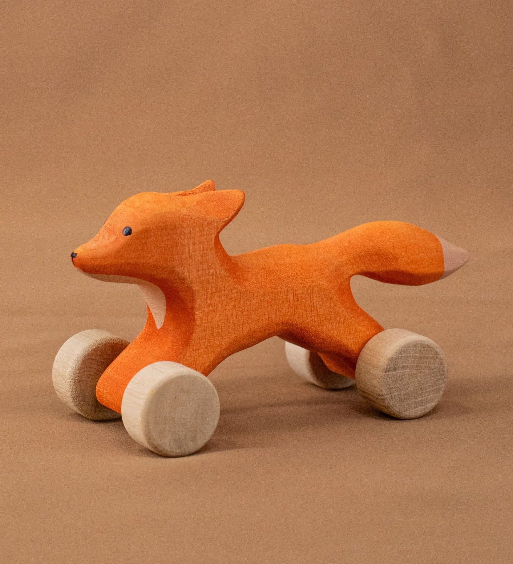 Bumbu handmade and hand painted rolling fox standing on a soft brown cloth