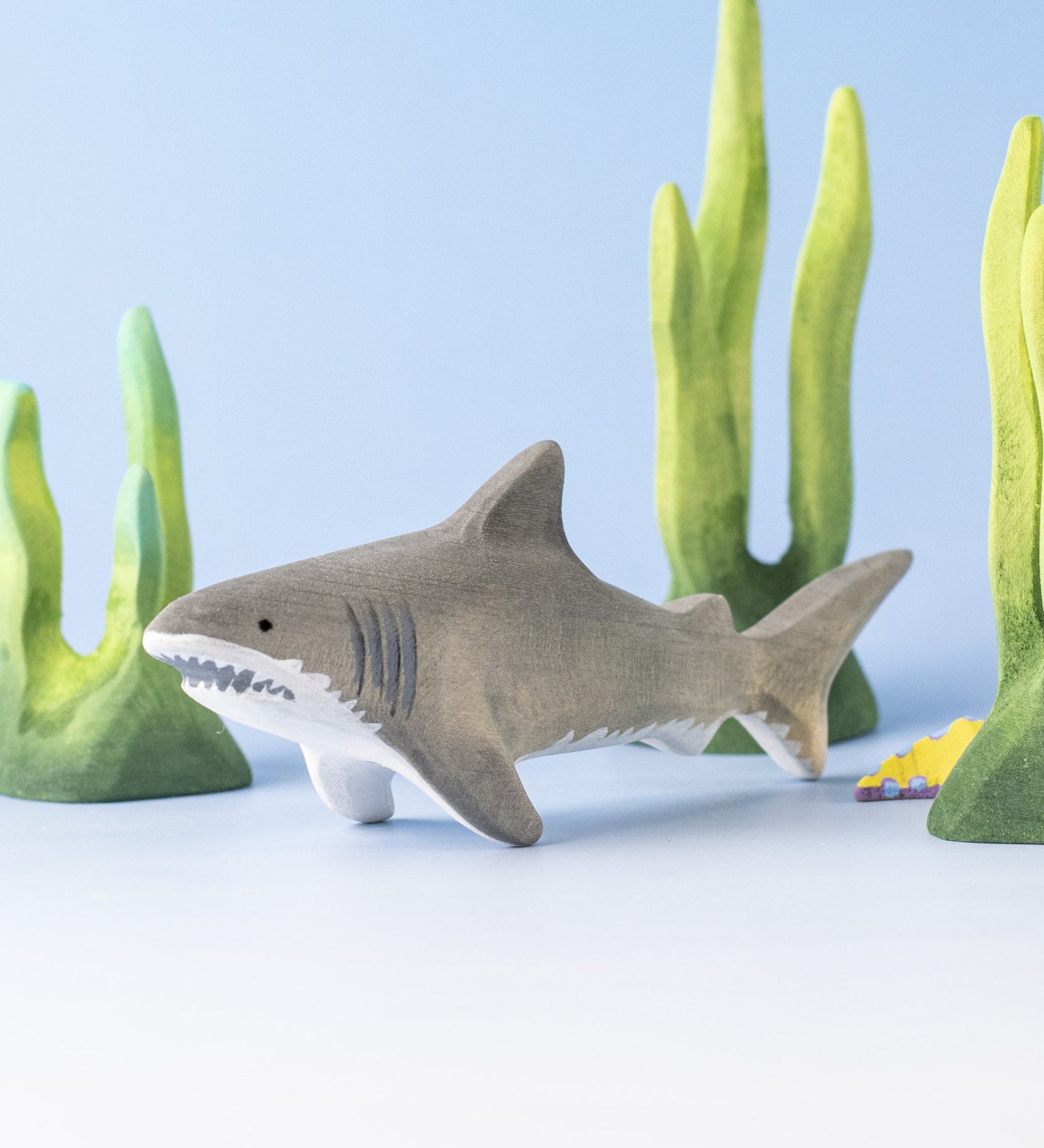 Bumbu handmade and hand painted wooden grey shark surrounded by the Bumbu green coral figures