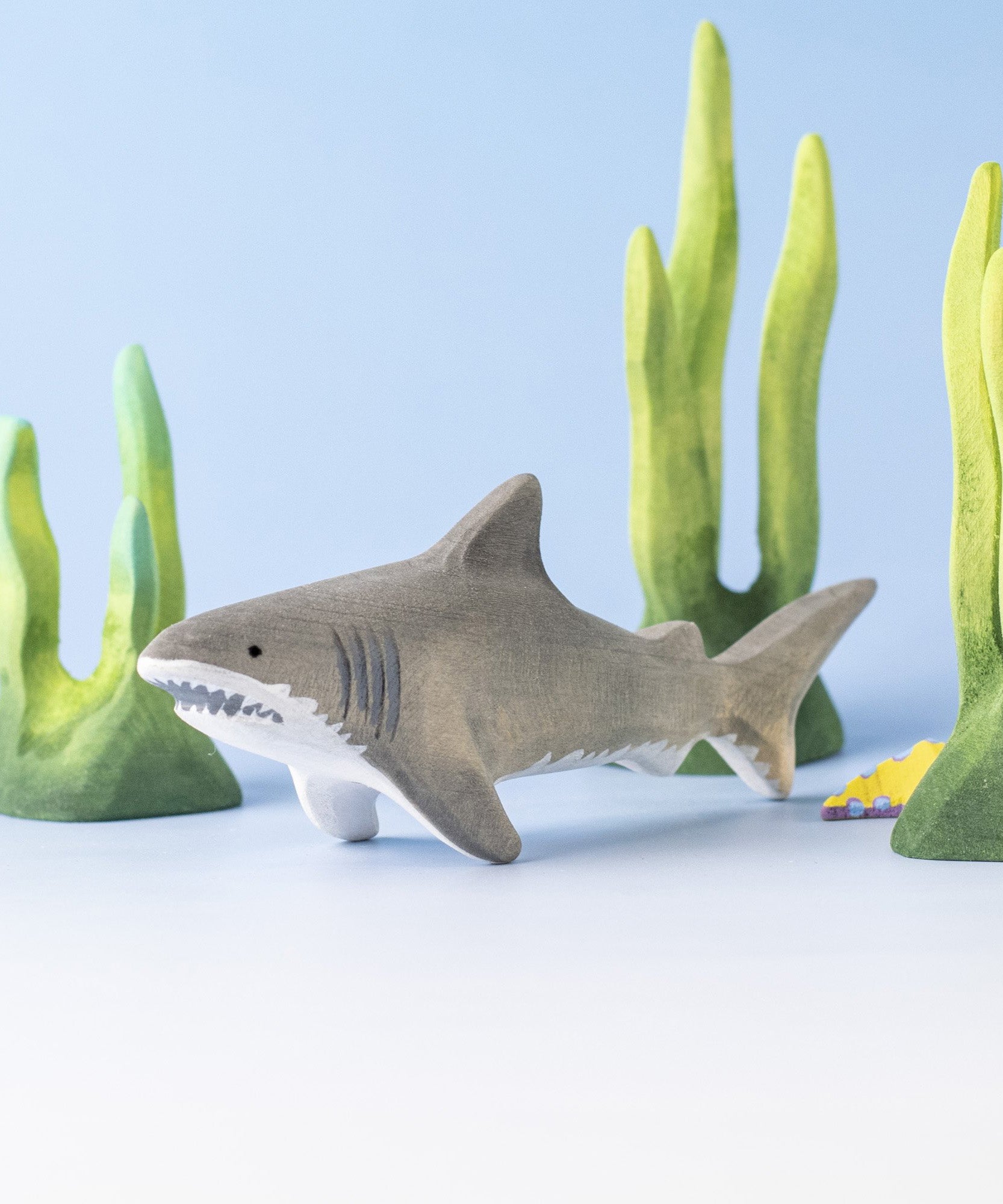 Bumbu handmade and hand painted wooden grey shark surrounded by the Bumbu green coral figures