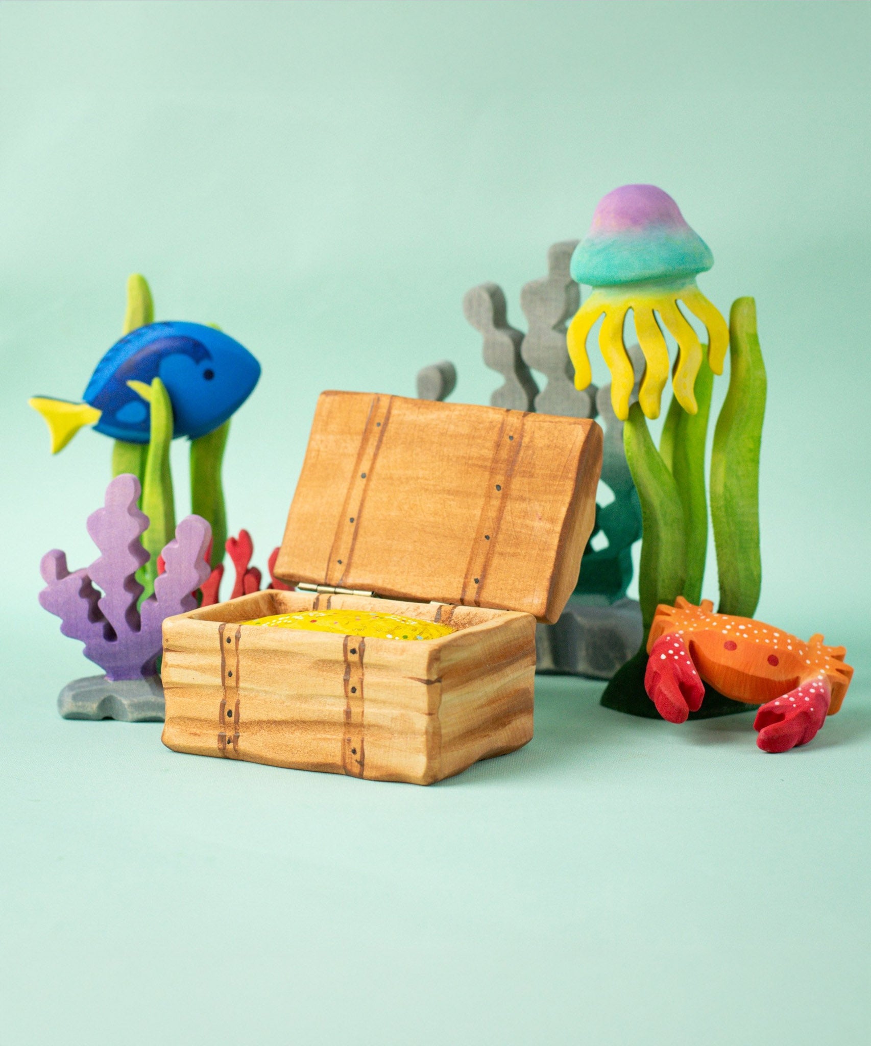 Bumbu handmade and hand painted wooden treasure chest in a deep sea playscene which includes various under the sea themed animal figures
