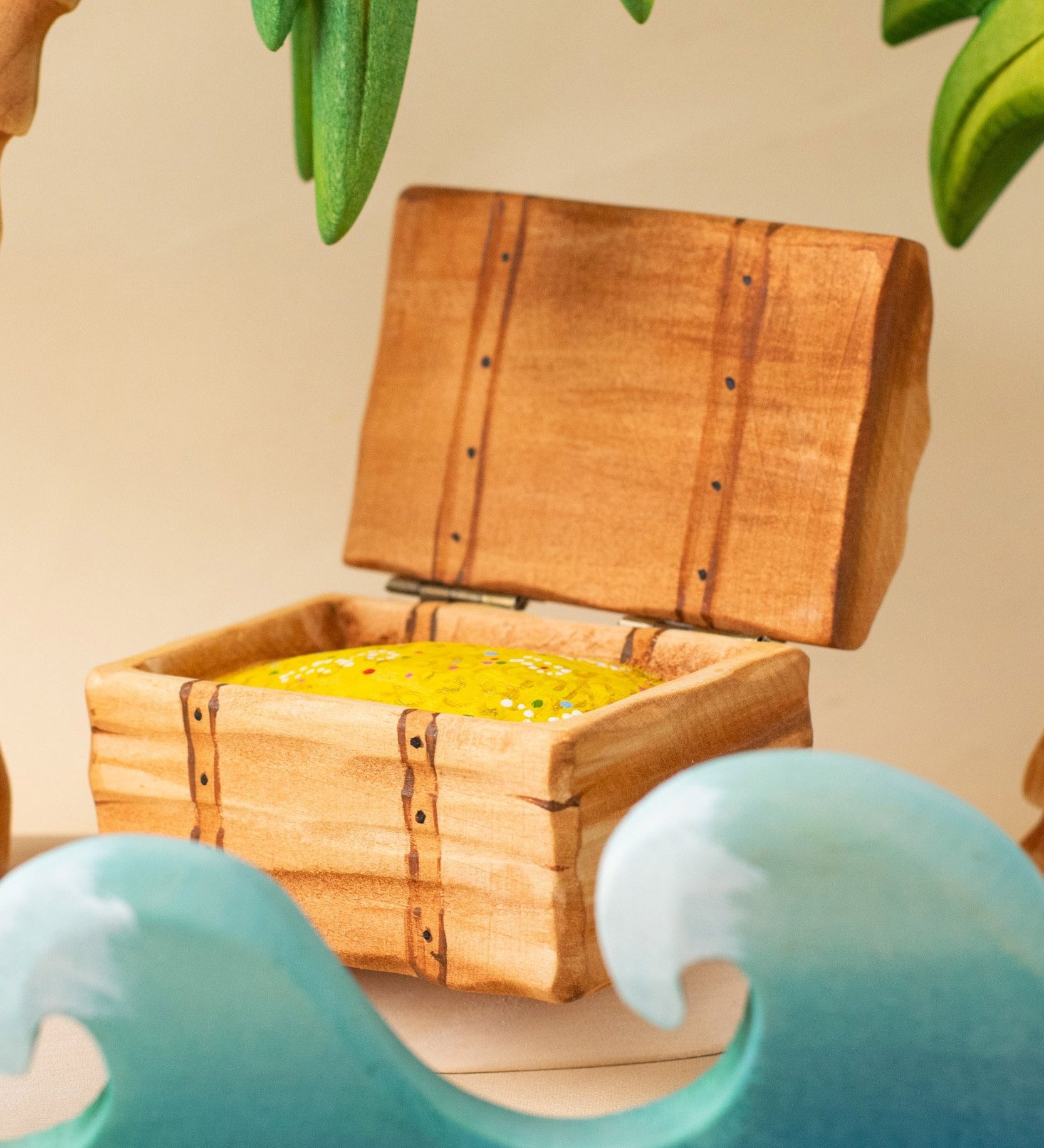 Bumbu handmade and hand painted wooden treasure chest in a ocean playscene which includes palm trees and ocean waves.