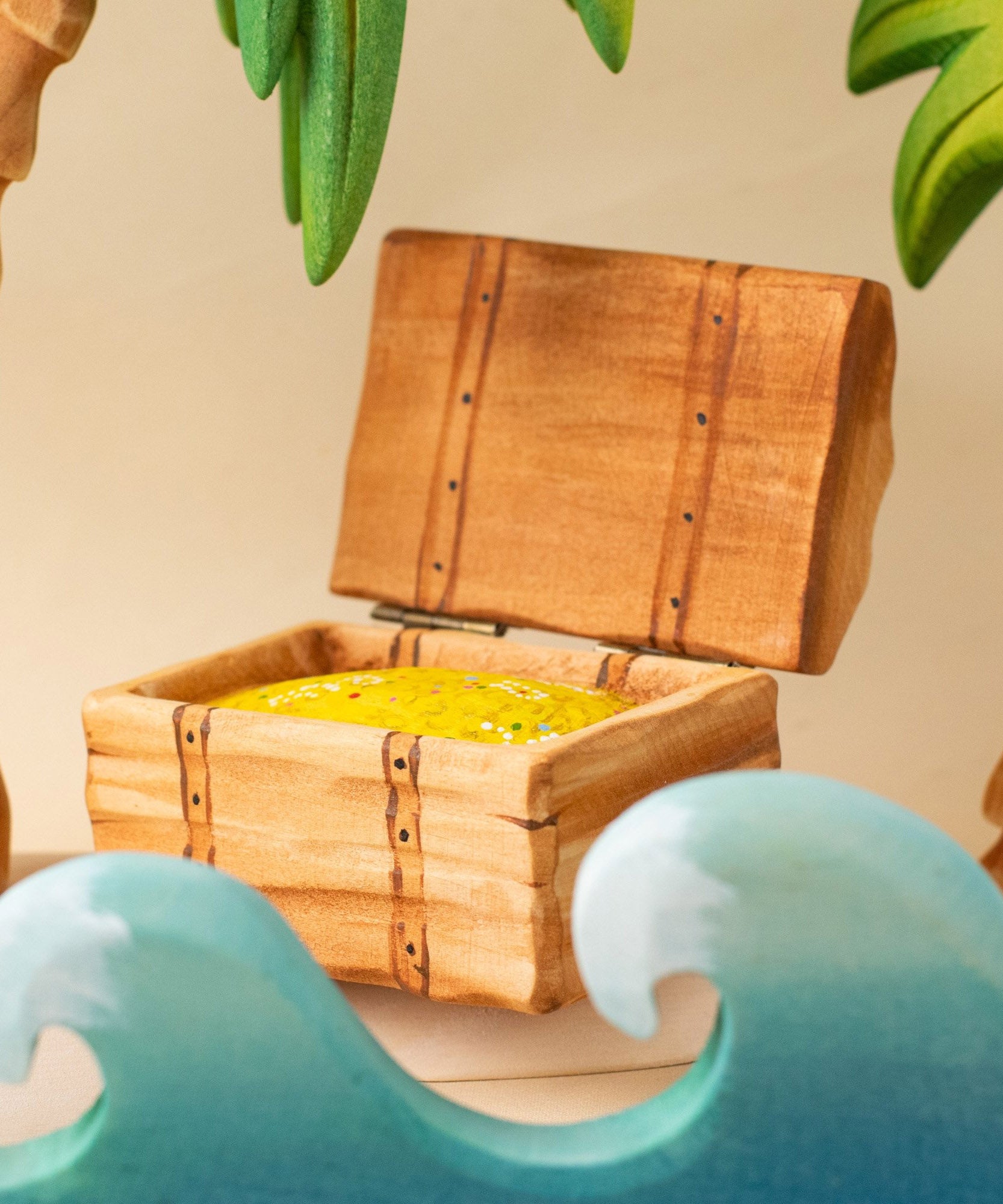 Bumbu handmade and hand painted wooden treasure chest in a ocean playscene which includes palm trees and ocean waves.