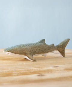 Bumbu handmade and hand painted wooden grey whale shark figure available at Babipur and resting on a wooden surface