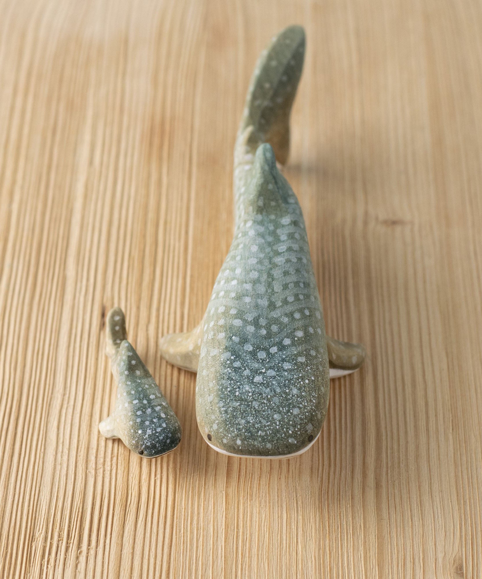 Bumbu handmade and hand painted wooden grey whale shark figure next to a baby whale shark figure available at Babipur 