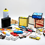 A colourful car construction scene, with coloured boxes, car parts, pens, markers, and a spray can laid out on a light grey background