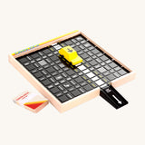The Candylab Gridlock Puzzle Board Game, with a yellow wooden car on the traffic puzzle board, game cards and a black ramp attached to the board, on a cream background