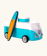 The Candylab VW Beach bus in blue, with a wooden blue and yellow surf board propped up next to the van, The image is on a cream background
