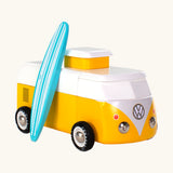 The Candylab VW Beach bus in yellow, with a wooden blue and white stripe surf board propped up next to the van, The image is on a cream background