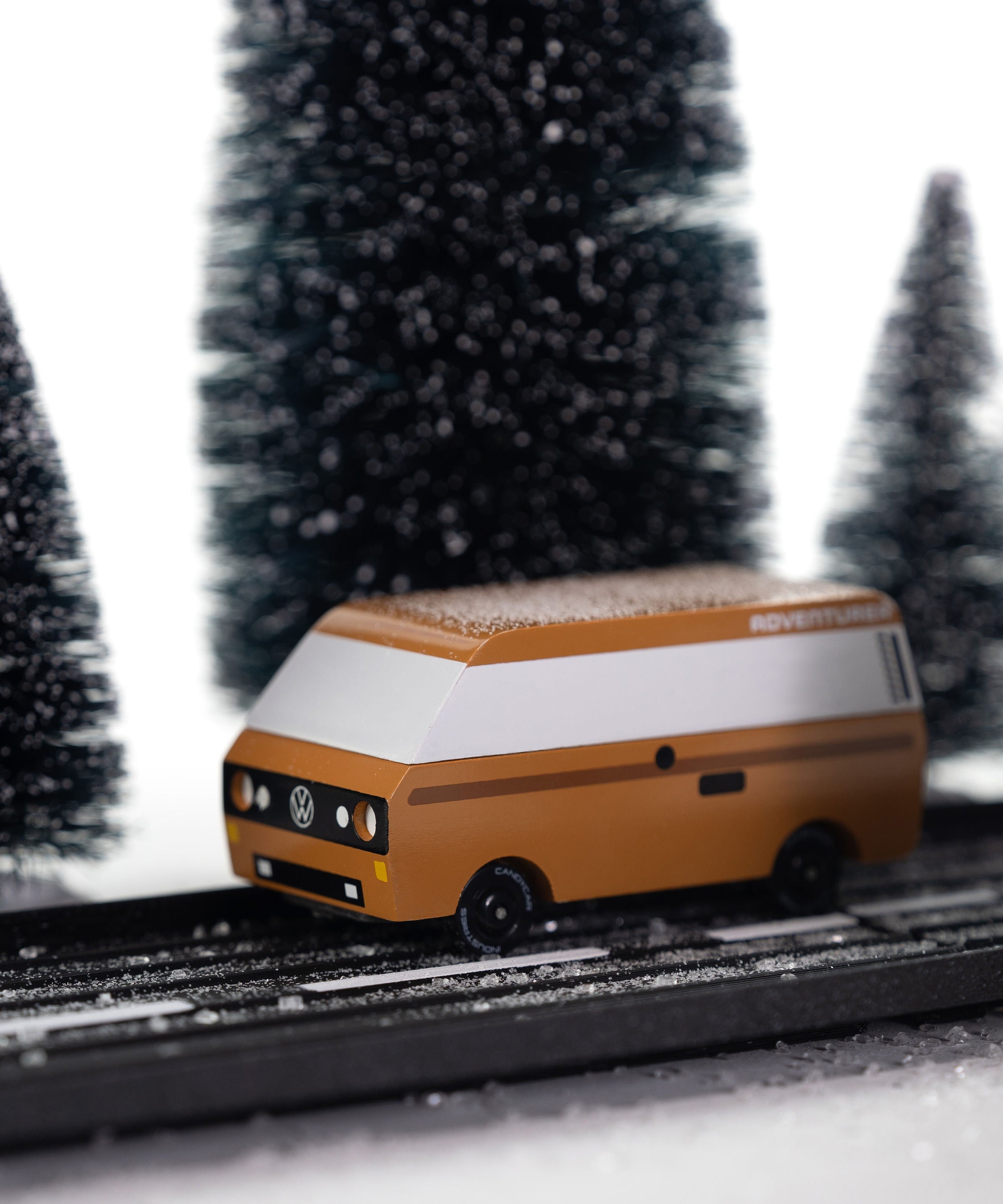 CandyLab VW T3 Campervan in brown - side view, placed on a road in a snowy forest environment.