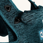 A closer look at the adjustable and removeable head and neck support on the Carifit+ Baby Carrier in Cool Green. The image shows the head and neck support attached to the carrier with a black clip attached to the carrier and an elasticated loop on the head and neck support