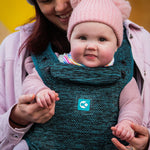 A child facing outwards in the multi-positional Carifit+ Baby Carrier in Cool Green