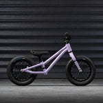 A side on view of the Early Rider Charger Balance Bike - Violet Haze, on a grey background