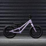 A side on view of the Early Rider Charger Balance Bike - Violet Haze, on a grey background