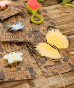 The Oli & Carol Natural Rubber Teether - Katia The Butterfly with other Oli & Carol teethers on their cardboard packaging slip
