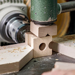 A closer look at the block creating process at Cuboro. The image shows a wooden block being cut into a marble run piece on a cutting machine
