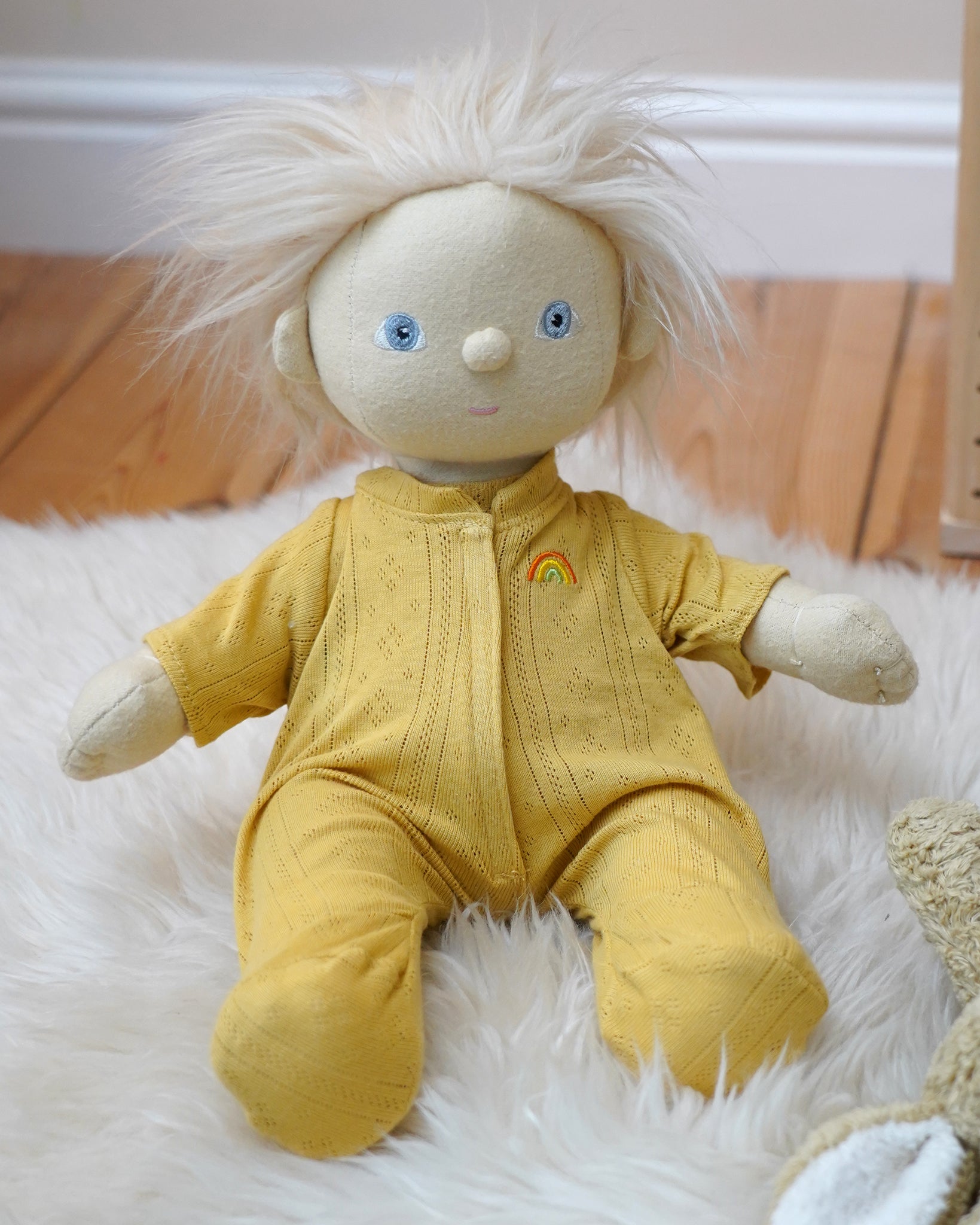 Olli Ella Dinkum Doll wearing a honey yellow pointelle PJ set with vest, pants, and babygrow, available to buy at Babipur.
