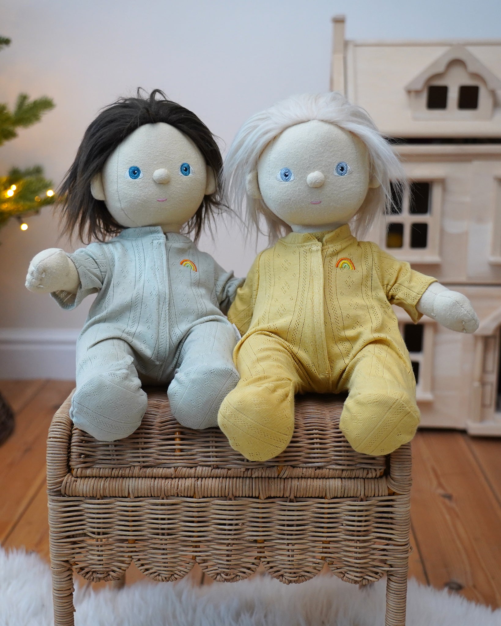 Pair of Olli Ella Dinkum Dolls wearing matching pointelle pyjamas in honey yellow and sage green, available to buy at Babipur.