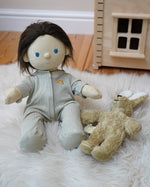 Olli Ella Dinkum Doll wearing a sage pointelle PJ set -  comes with a vest, pants and babygrow in a light green pattern - for sale at Babipur. 