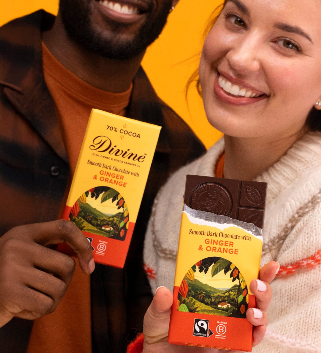 2 adults holding Divine fairtrade smooth dark chocolate with ginger and orange bars with one opened