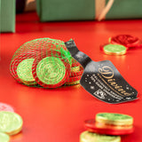 Divine fairtrade dark chocolate coins inside the green netted bag with other different sized coins scatted. Chocolate coins available at Babipur.