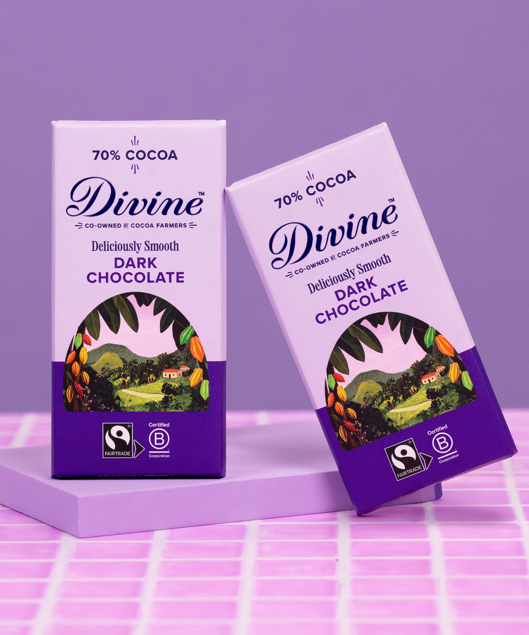 2 bars of Divine fairtrade smooth 70% dark chocolate standing on a purple platform