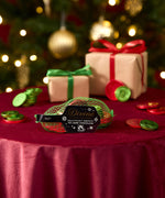 Divine fairtrade milk chocolate inside the green netted bag with various festive decorations in a background. Chocolate coins available at Babipur 